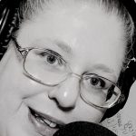 White women white headphone, and a microphone wearing glasses