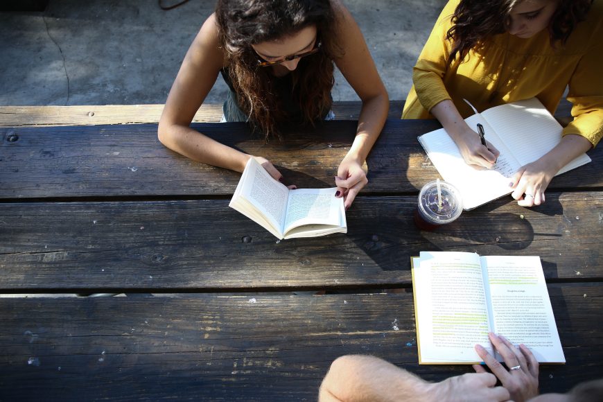 Women seating at a table with notebooks